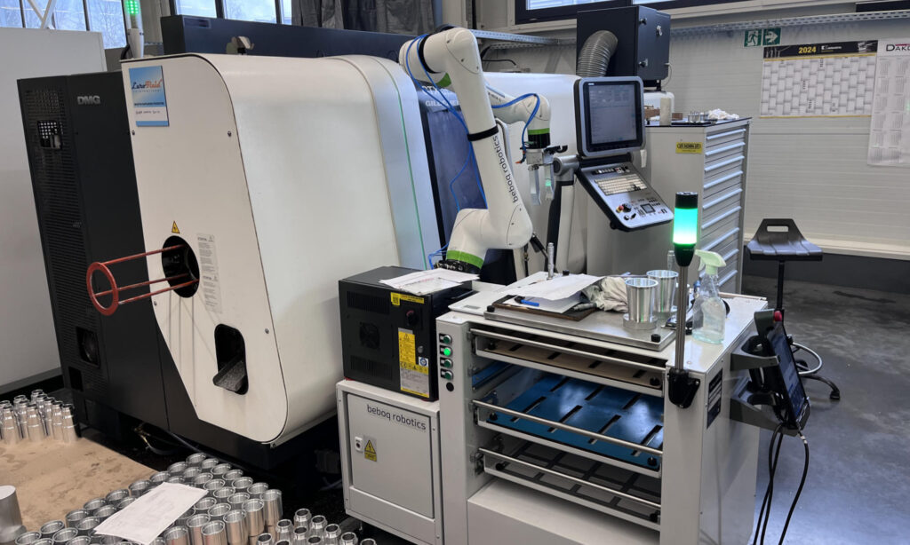 Fanuc CRX obsługuje tokarkę CNC. Otwarta przestrzeń stanowiska. Wieloszufladowy zasobnik na detale.