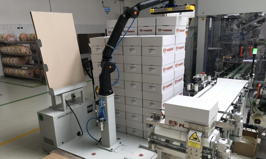 Robot kolaboracyjny paletyzuje opakowania automatyczne klejone.