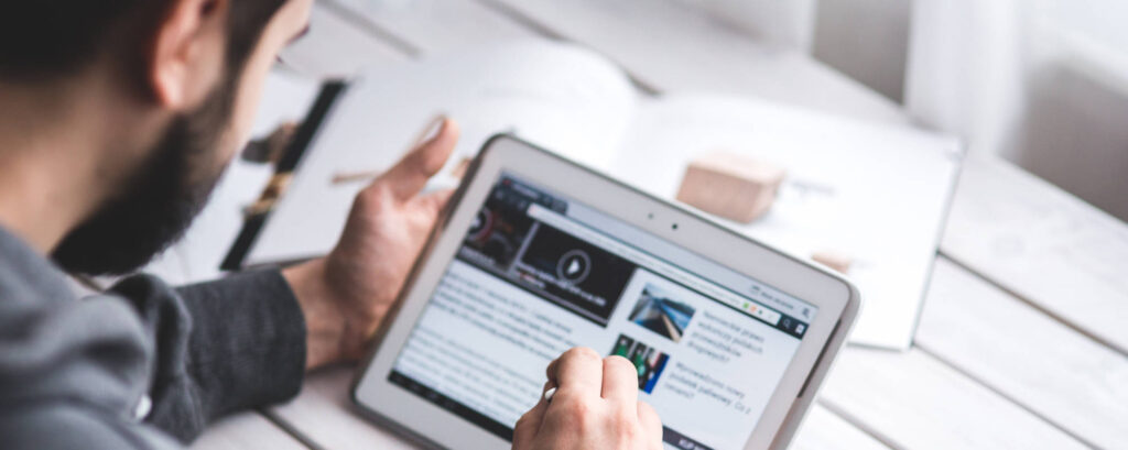 Man reading newsletter on a tablet.