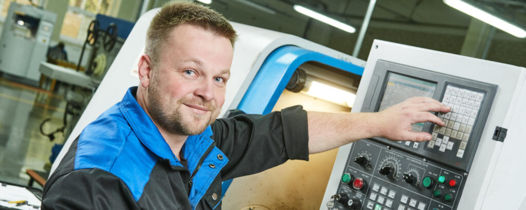 Banner. Industrial factory worker or service engineer operating cnc turning lather machine at factory in metal machining industry
